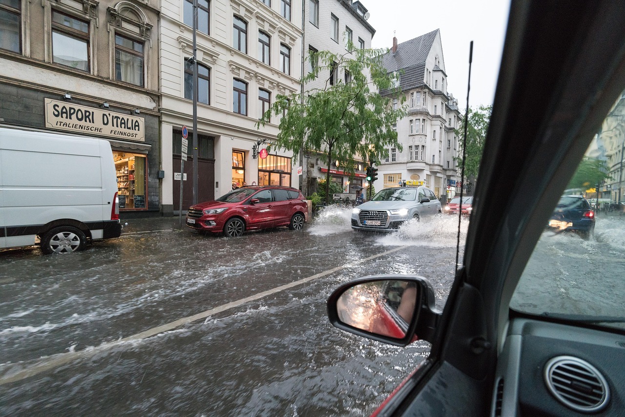 Photo d’une rue inondée avec des voitures submergées après de fortes pluies, illustrant les inondations urbaines et les risques liés aux pluies intenses.